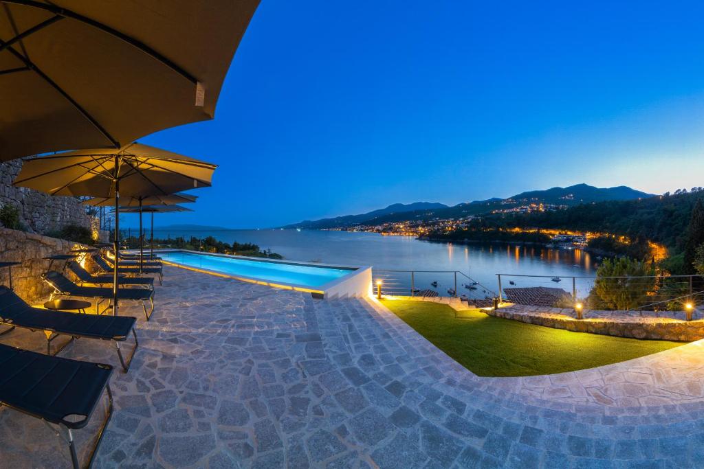 una piscina con vista sul lago di notte di Mare Sano apartment #5 a Opatija
