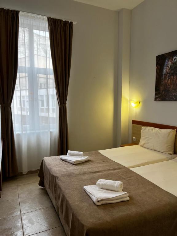 a hotel room with two beds with towels on them at Hotel CENTRAL Balchik in Balchik
