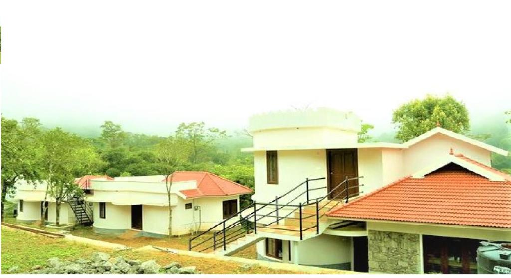 a group of houses with red roofs at Jungle Villa Munnar in Pooppara