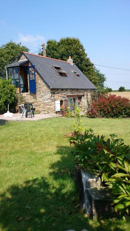 une petite maison en pierre au milieu d'une cour dans l'établissement Avel Nedeleg, à Coatreven