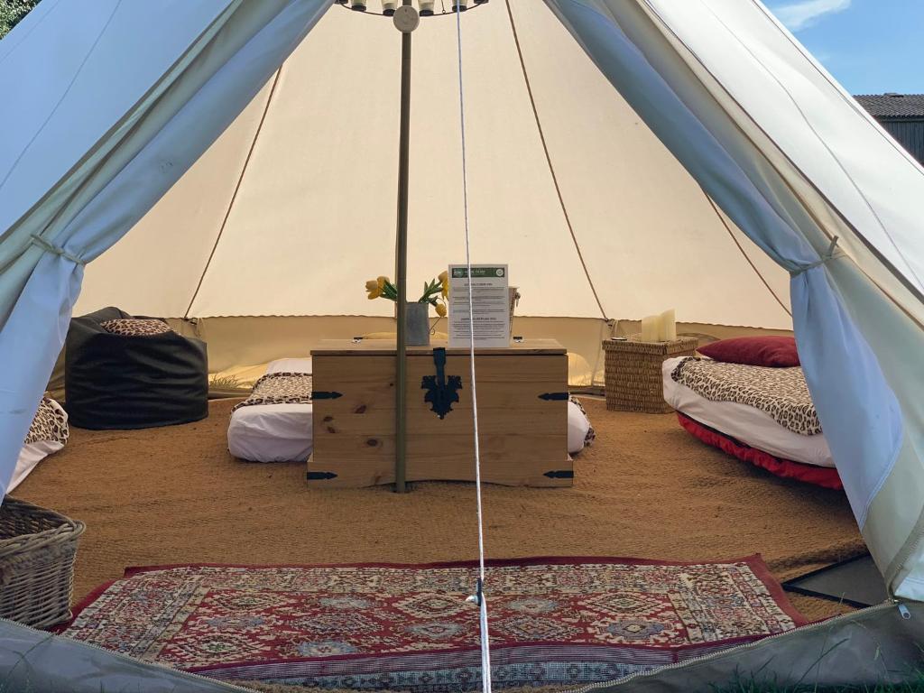 uma tenda com duas camas e uma mesa em Home Farm Radnage Glamping Bell Tent 1, with Log Burner and Fire Pit em Radnage