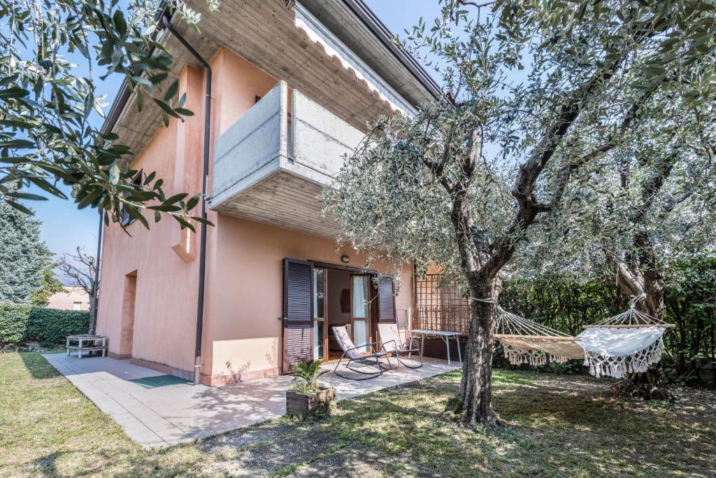 ein Haus mit einem Baum und einer Hängematte im Hof in der Unterkunft Casa Angela in San Felice del Benaco