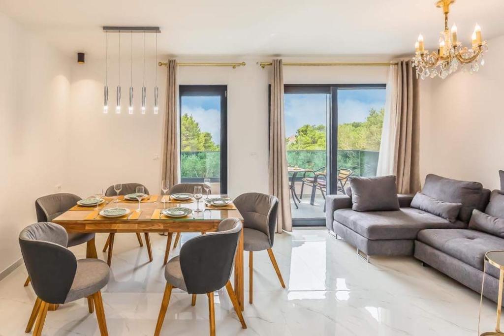 uma sala de estar com uma mesa e cadeiras e um sofá em ŽIŽI exclusive apartments em Tučepi