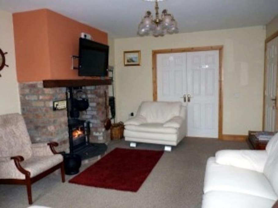 Fermanagh lakeside Self Catering في Corranny: غرفة معيشة مع أريكة ومدفأة