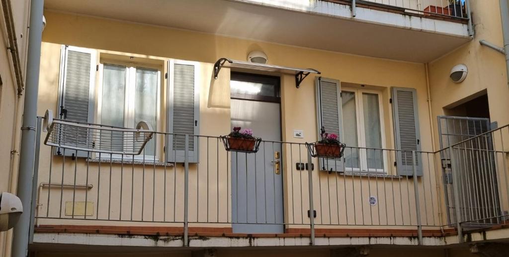 ein Gebäude mit Fenstern und Balkonen mit Blumen in der Unterkunft Casa vacanze il Tuffetto in Olginate