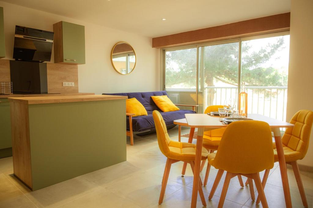 een keuken en een woonkamer met een tafel en stoelen bij Magnifique appartement de type loft en front de mer avec vue, parking et WiFi in Argelès-sur-Mer