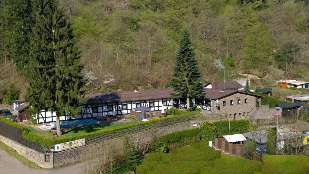 uma vista aérea de um edifício com uma cerca e árvores em Landgasthaus Tannenhof em Ahrbrück