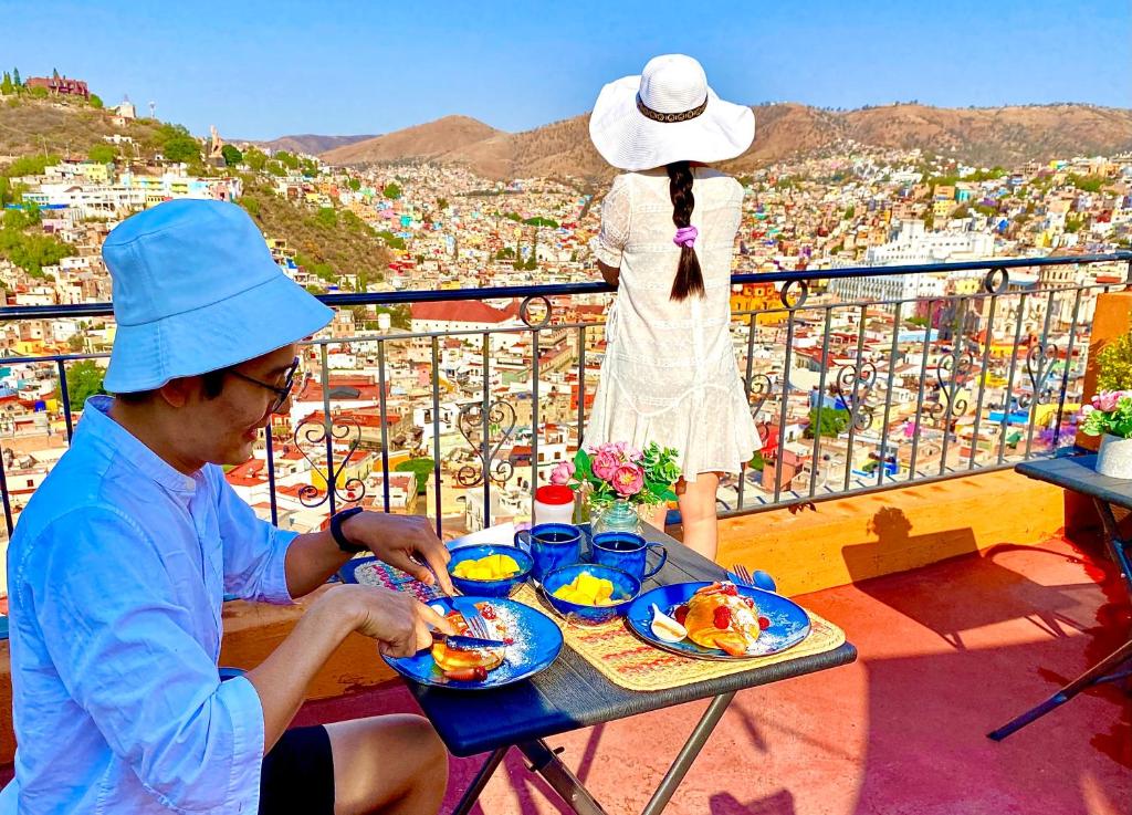 un hombre sentado en una mesa con un plato de comida en Casa Rofo en Guanajuato