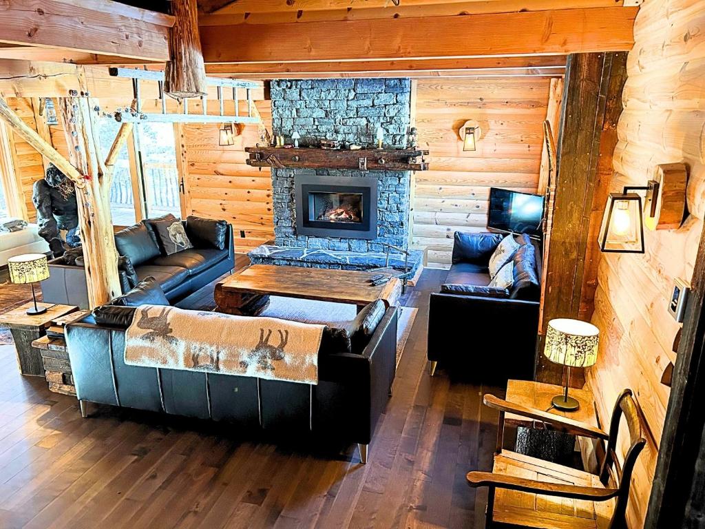 ein Wohnzimmer mit einem Sofa und einem Kamin in der Unterkunft BIGFOOT - Chalets de Môh - Jacuzzi in La Malbaie