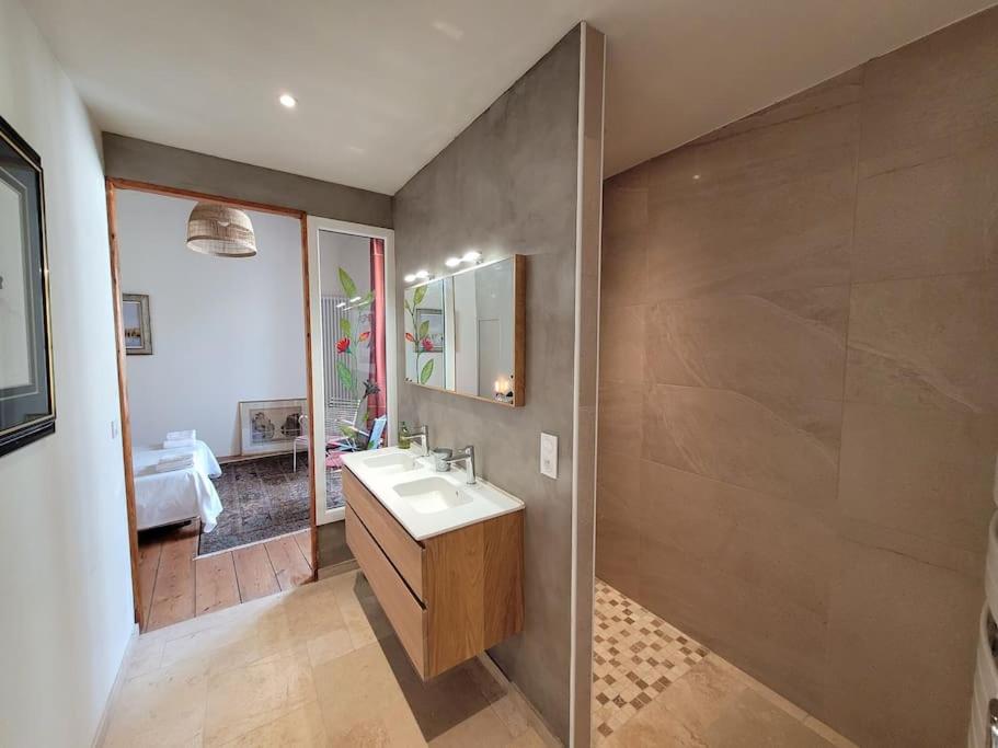 La salle de bains est pourvue d'un lavabo et d'un miroir. dans l'établissement LA MAITRISE, à Bayeux