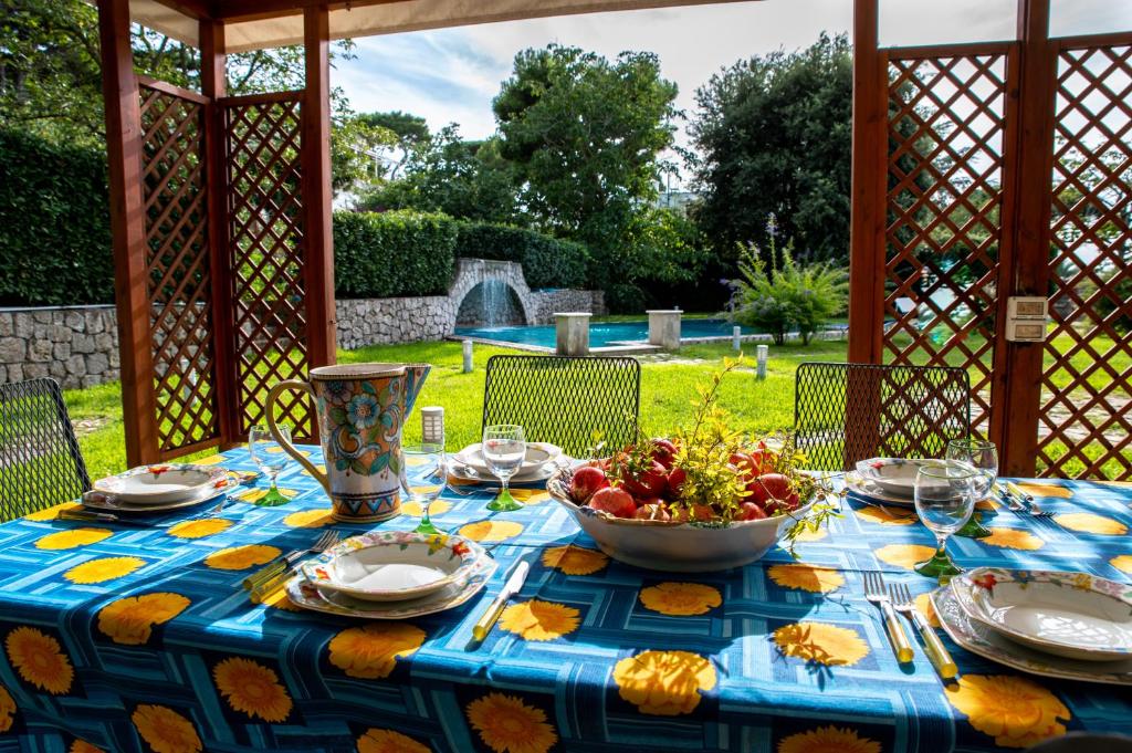 a table with a blue table cloth with a bowl of fruit at Capri Villa Vittoria by Capri Property in Anacapri