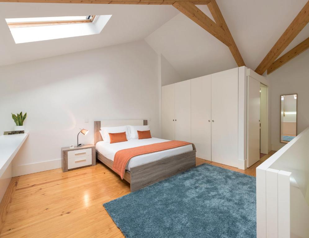 een slaapkamer met een bed en een blauw tapijt bij Apartment Firehouse by Sweet Porto - Free Parking in Porto