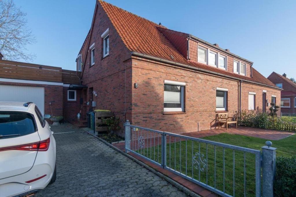a car parked in front of a brick house at Ferienwohnung-Moewenblick in Norden