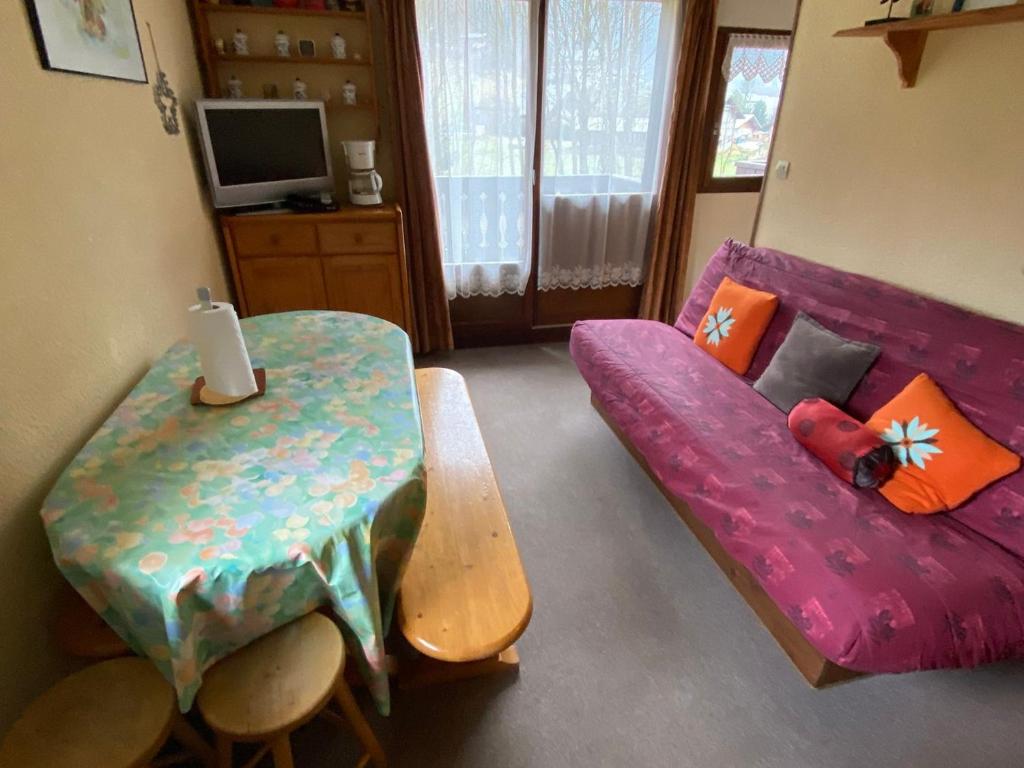 een woonkamer met een paarse bank en een tafel bij Studio Abondance, 1 pièce, 4 personnes - FR-1-692-55 in Abondance