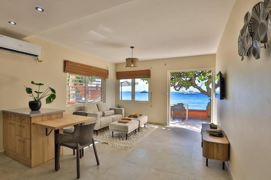 uma cozinha e sala de estar com mesa e cadeiras em Hamaka condo a beachfront retreat on Simpson Bay Beach em Simpson Bay