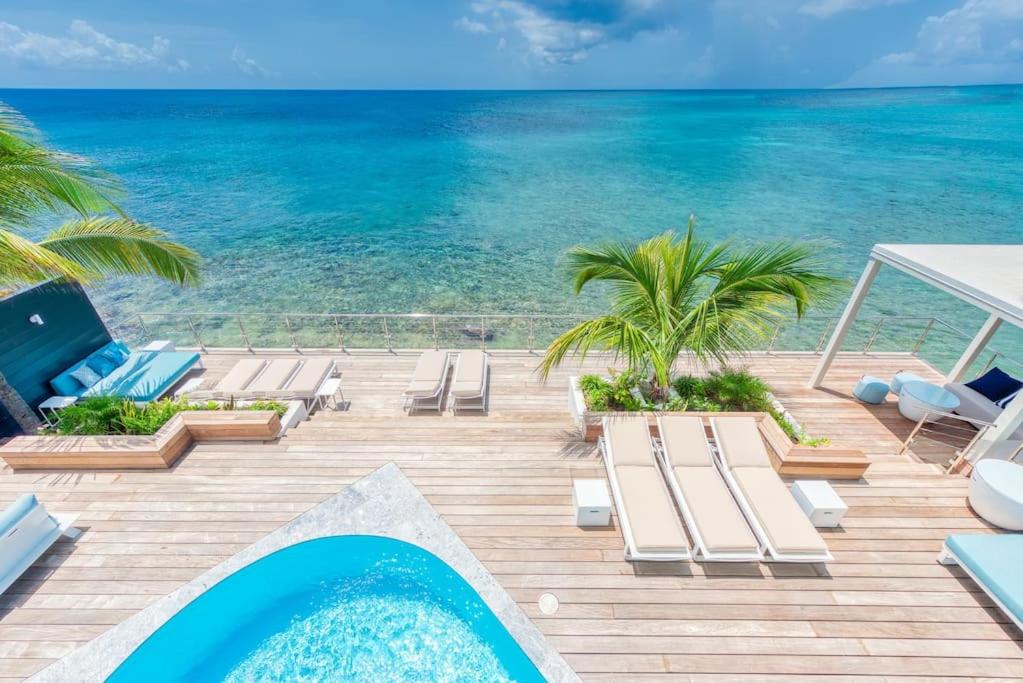 einen Blick auf das Meer von einem Resort mit Pool in der Unterkunft Surfsong Villa- Luxury Water Front Villa for 12 in Maho Reef