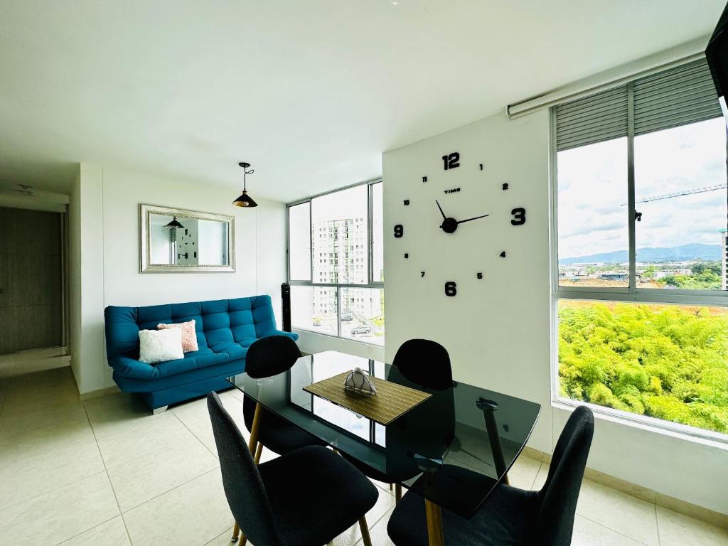un soggiorno con divano blu e orologio sul muro di Hermoso apartamento pereira con parking y piscina a Pereira