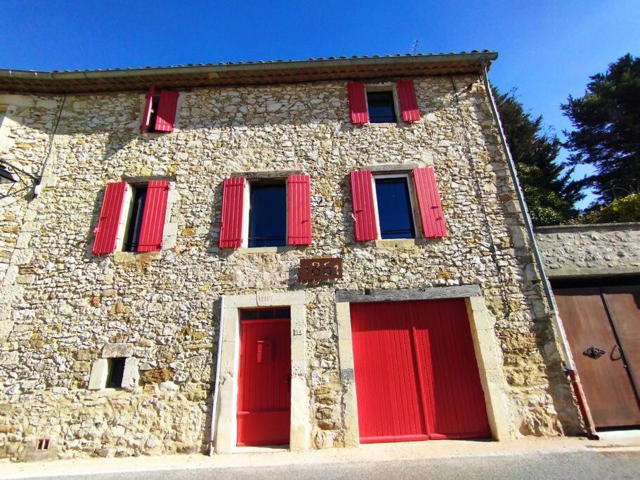 ein Steingebäude mit roten Fensterläden in der Unterkunft Grande Maison Luberon Ventoux in Aurel