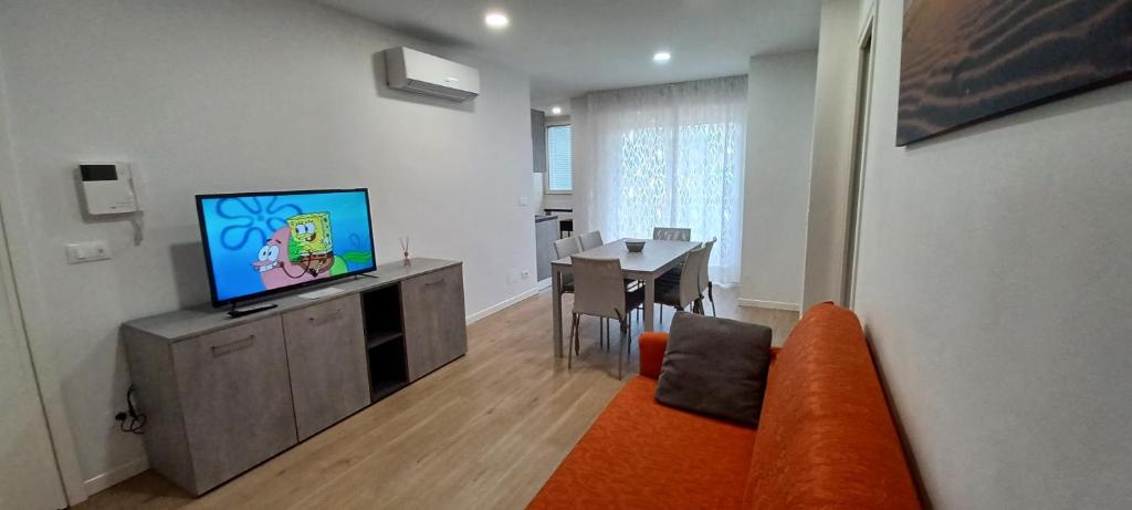 利尼亞諾薩比亞多羅的住宿－Casa Bivi 2，客厅配有橙色沙发和电视