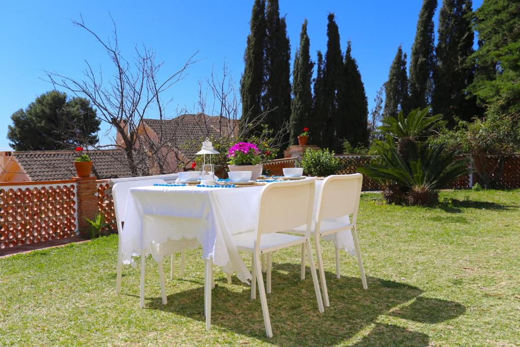 - une table et des chaises blanches dans le jardin dans l'établissement VILLA CLAVERO ONE Premium Apt, à Malaga