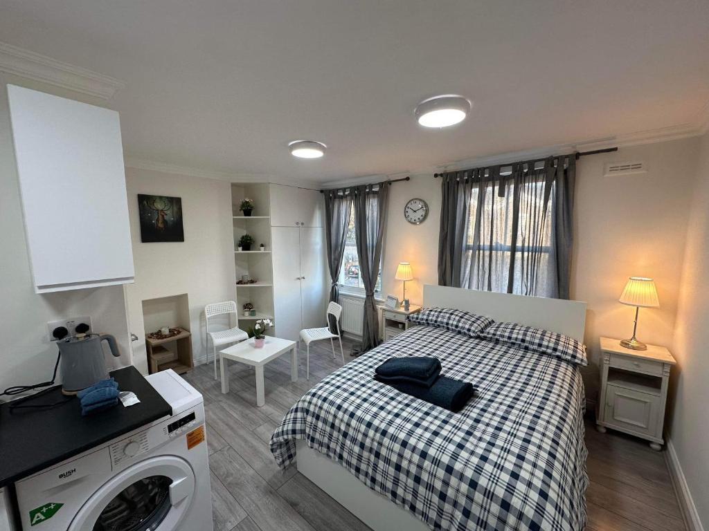 een slaapkamer met een bed en een wasmachine bij Guest and Rest 7 in Londen