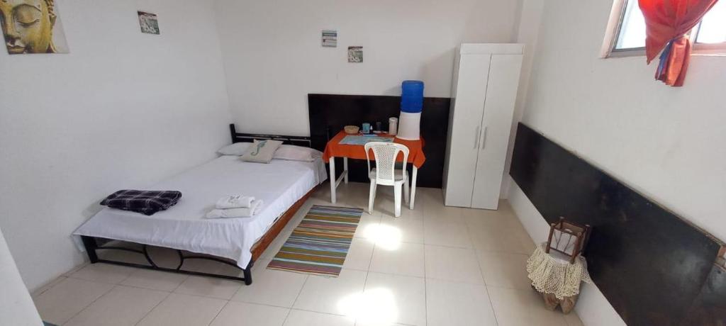 een kleine slaapkamer met een bed en een tafel bij La Casa de Mike in Puerto Villamil