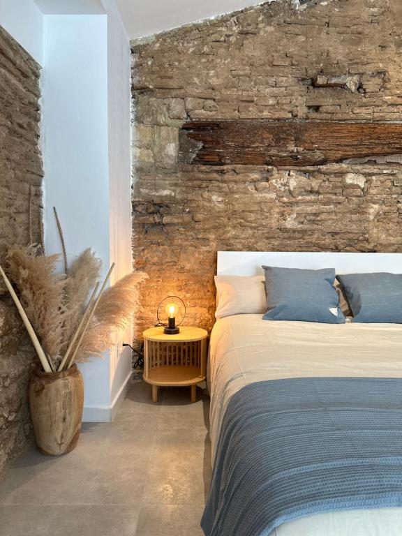 a bedroom with a bed and a brick wall at ART HOMES LAVADERO in Valencia