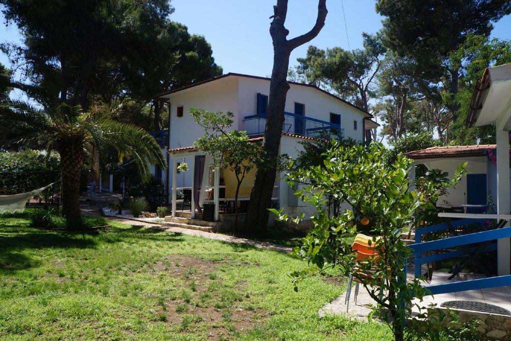 une maison blanche avec des arbres et une cour dans l'établissement Appartamenti La Villa Peschici, à Peschici
