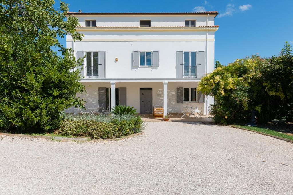 ein weißes Haus mit einer Einfahrt davor in der Unterkunft B&B Casale Savini in Ortona