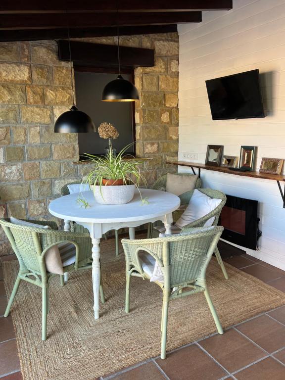 a patio with a table and chairs and a tv at Posada La Vieja Escuela in La Revilla
