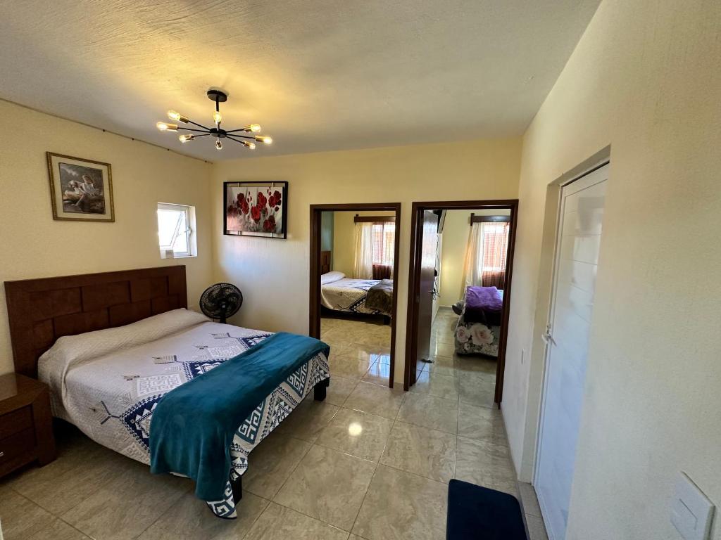 1 dormitorio con 1 cama y 1 habitación con espejo en Departamento en Tequila María Concepción, en Tequila