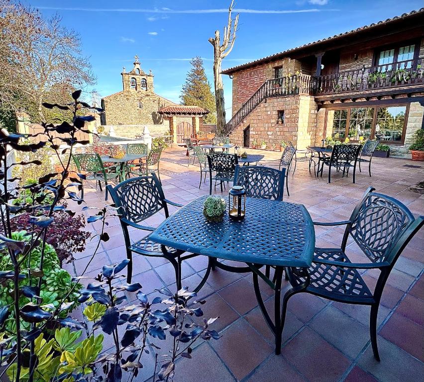 una mesa azul y sillas en un patio en Posada La Vieja Escuela, en La Revilla