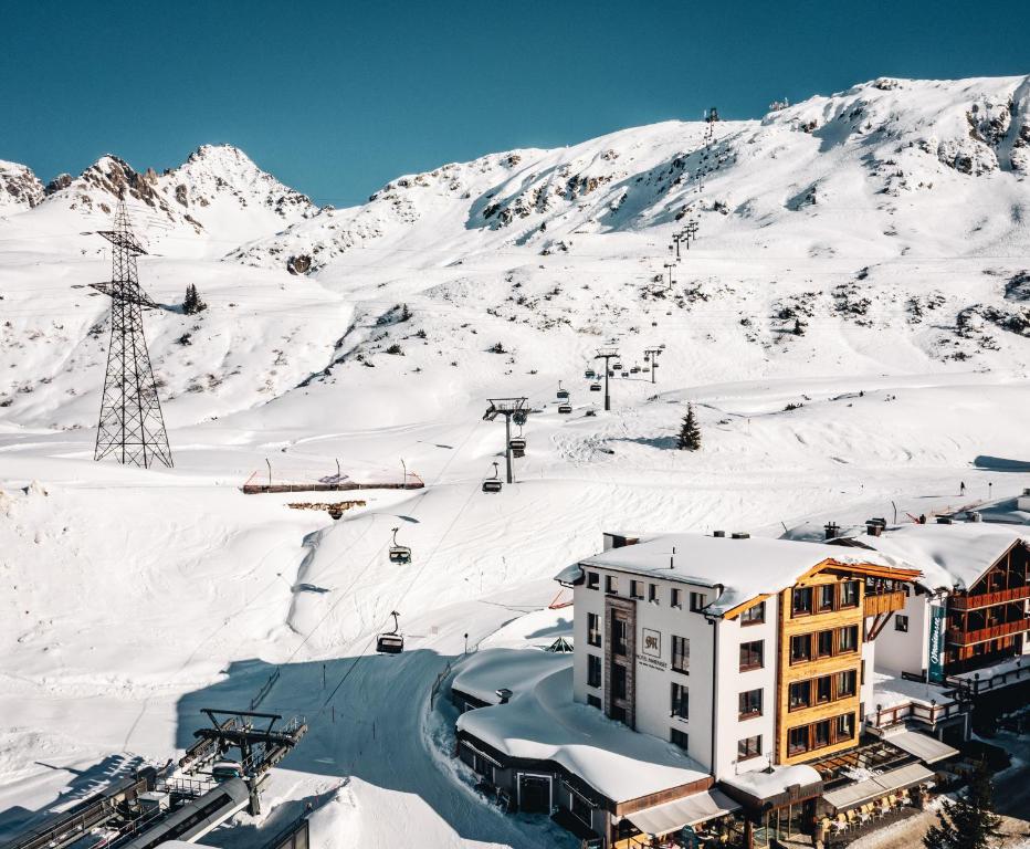 una stazione sciistica nella neve con impianto di risalita di Hotel Maiensee a Sankt Christoph am Arlberg
