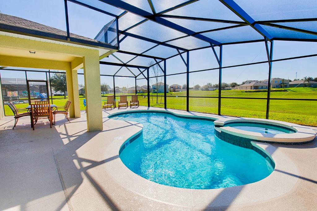 uma piscina numa casa com telhado em 10 Guest Villa in Tranquil Setting Near Disney Pool & Spa by Orlando Holiday Rental Homes 1153 em Davenport