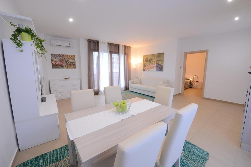 a white dining room with a white table and white chairs at Residence Rapisardi in Catania