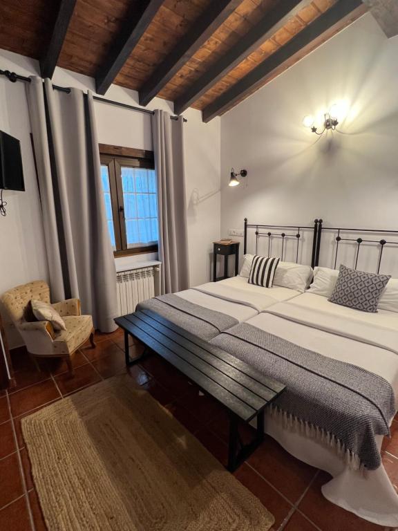 a bedroom with a large bed and a chair at Posada La Vieja Escuela in La Revilla