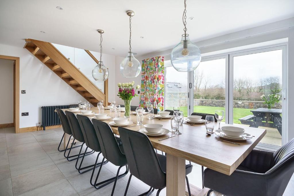 a large dining room with a long table and chairs at Ty Alwyn in Pwllheli