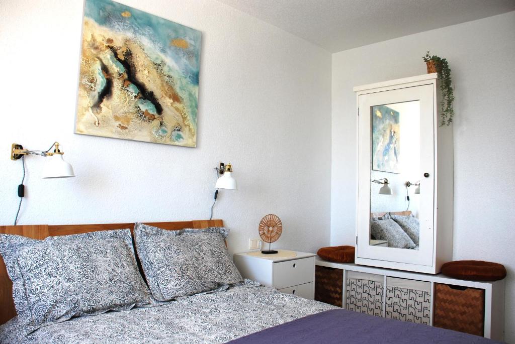 um quarto com uma cama e um espelho na parede em Casa Luna - Sea view apartment Bolnuevo em Bolnuevo