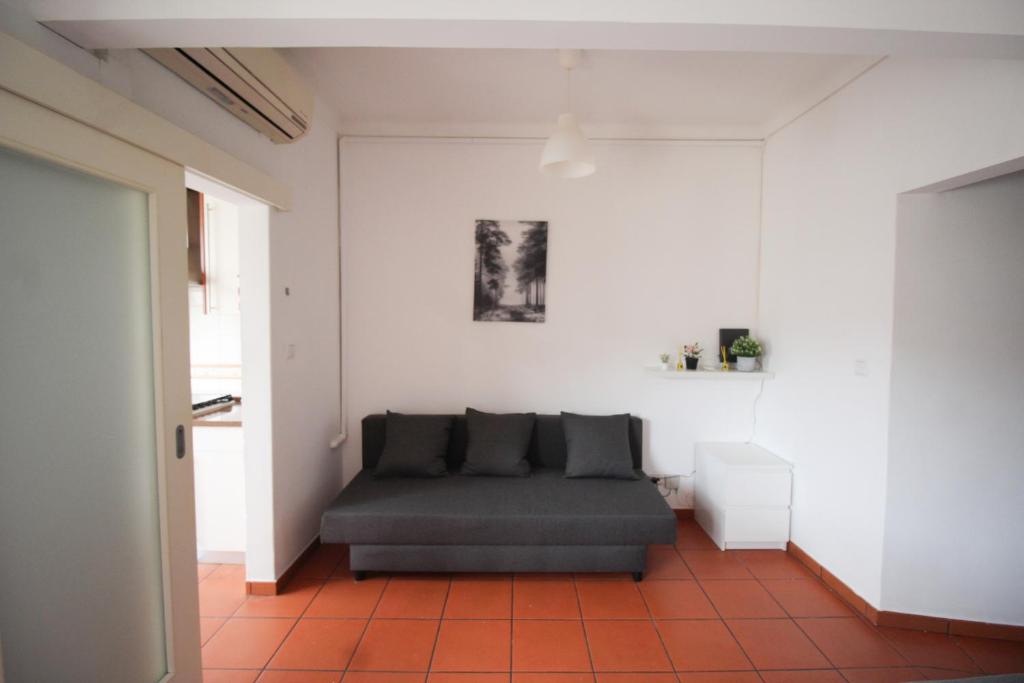 a living room with a gray couch and a white wall at Oriente DNA Studios VI in Lisbon