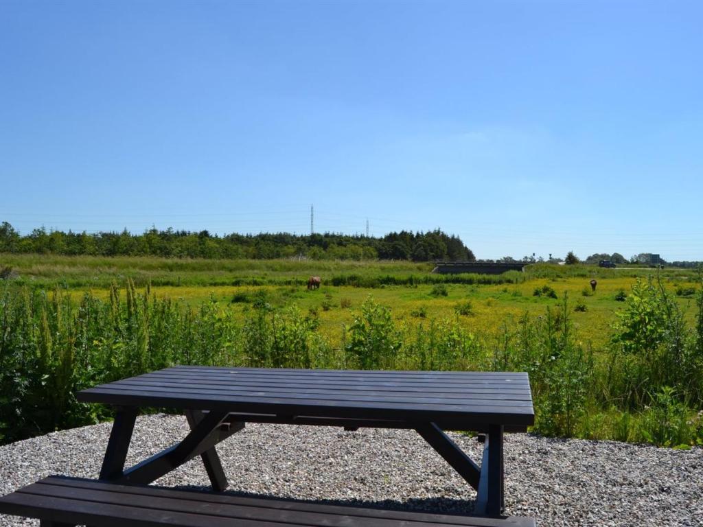 a wooden picnic table sitting on a gravel field at Apartment Gunhild - 22km from the sea in Western Jutland by Interhome in Bredebro