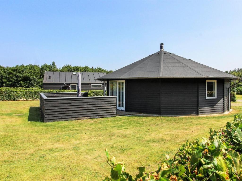 um pequeno edifício com um telhado num campo de relva em Holiday Home Jani - 25km from the sea in Western Jutland by Interhome em Toftlund