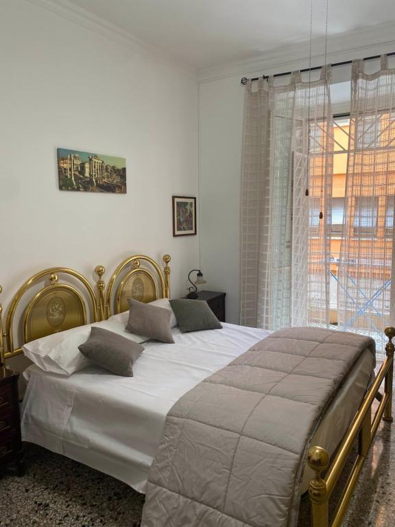 een slaapkamer met een groot bed met witte lakens en een raam bij Maria luisa house in Rome