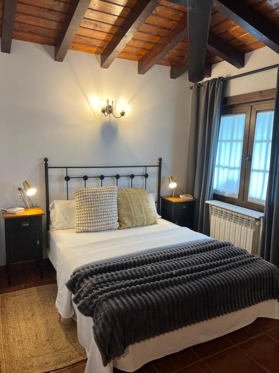 a bedroom with a large bed in a room with wooden ceilings at Posada La Vieja Escuela in La Revilla