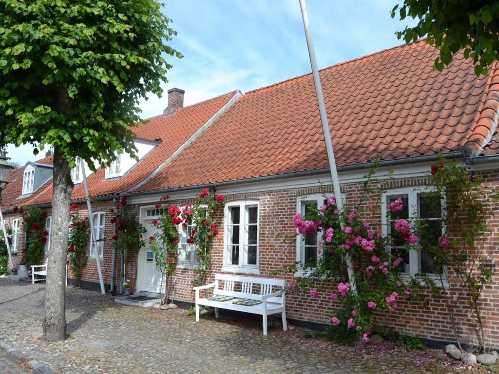 ein Backsteinhaus mit einer Bank davor in der Unterkunft Holiday Home Ajna - 9-8km from the sea in Western Jutland by Interhome in Tønder
