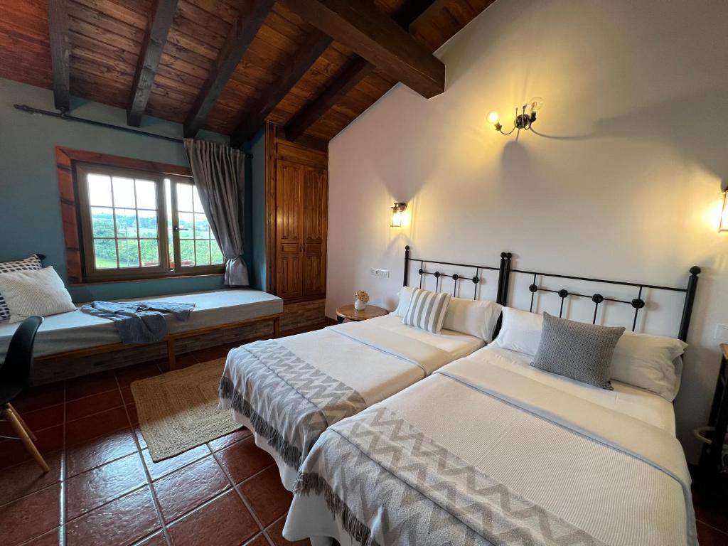 a bedroom with two beds and a window at Posada La Vieja Escuela in La Revilla