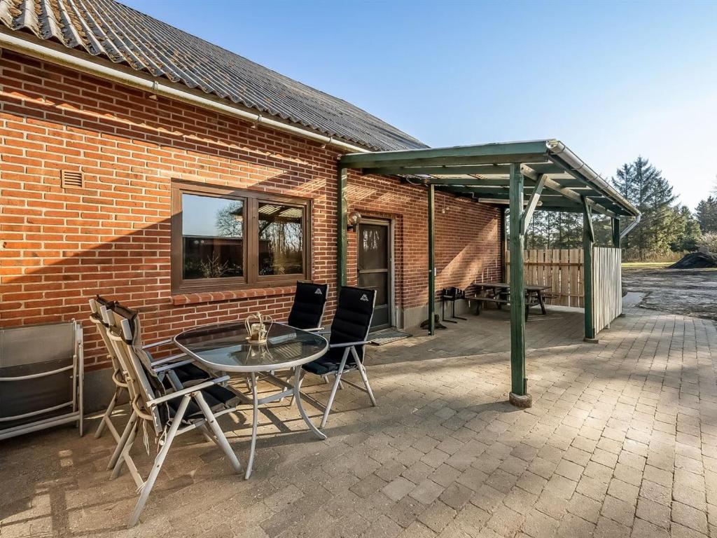 a patio with a table and chairs in front of a brick building at Apartment Gertraude - 17km to the inlet in Western Jutland by Interhome in Skjern