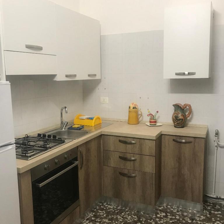 una cucina con armadi in legno e lavandino di Casa Pina a Rutigliano