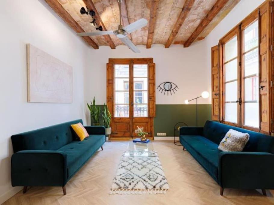 a living room with blue couches and a wooden ceiling at Spacious apartment in the Gothic in Barcelona