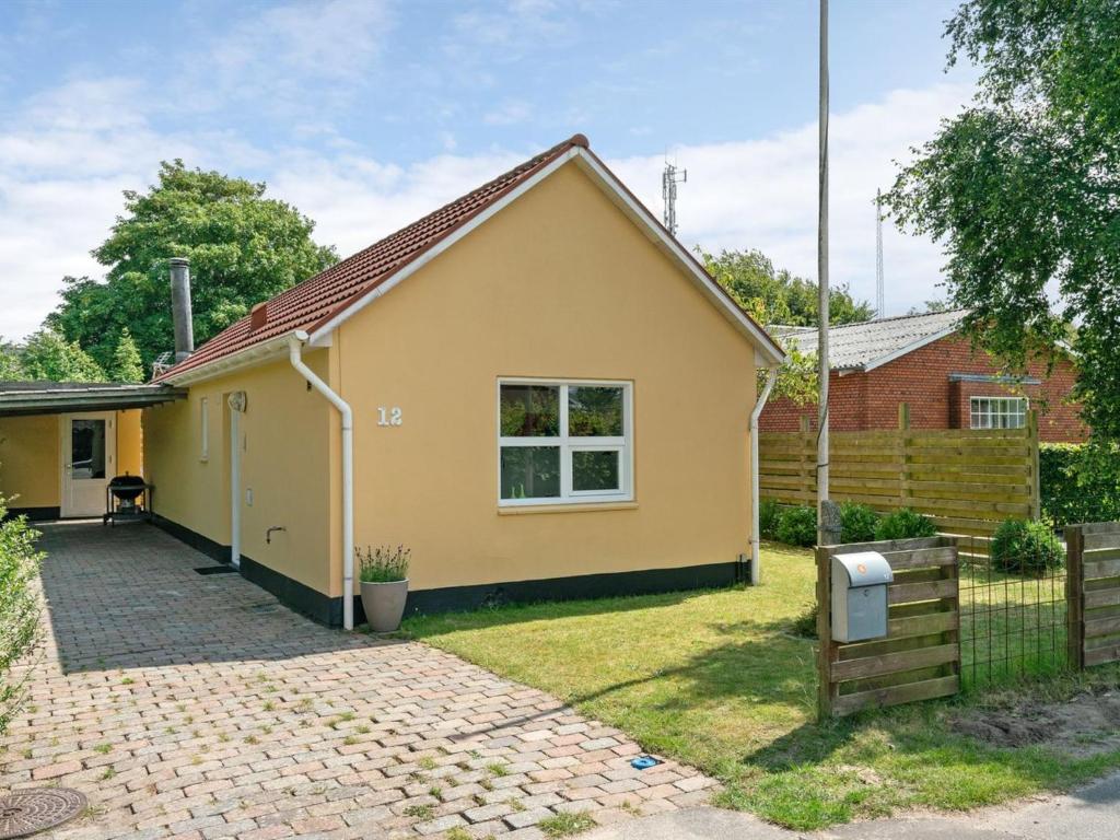 een geel huis met een hek en een tuin bij Holiday Home Øthi in Western Jutland by Interhome in Ribe