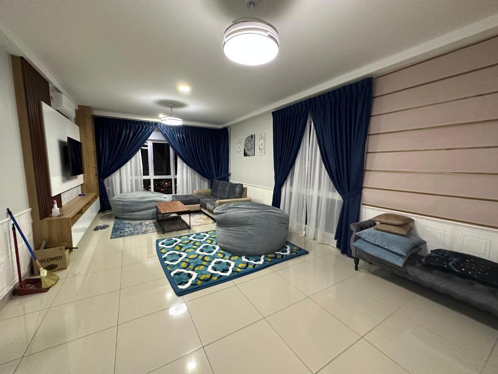 een woonkamer met blauwe gordijnen en een bank bij Suraya Homestay V’ Residence in Puchong